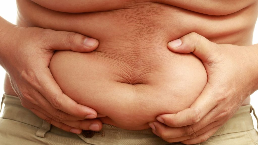 man holding his abdominal fat