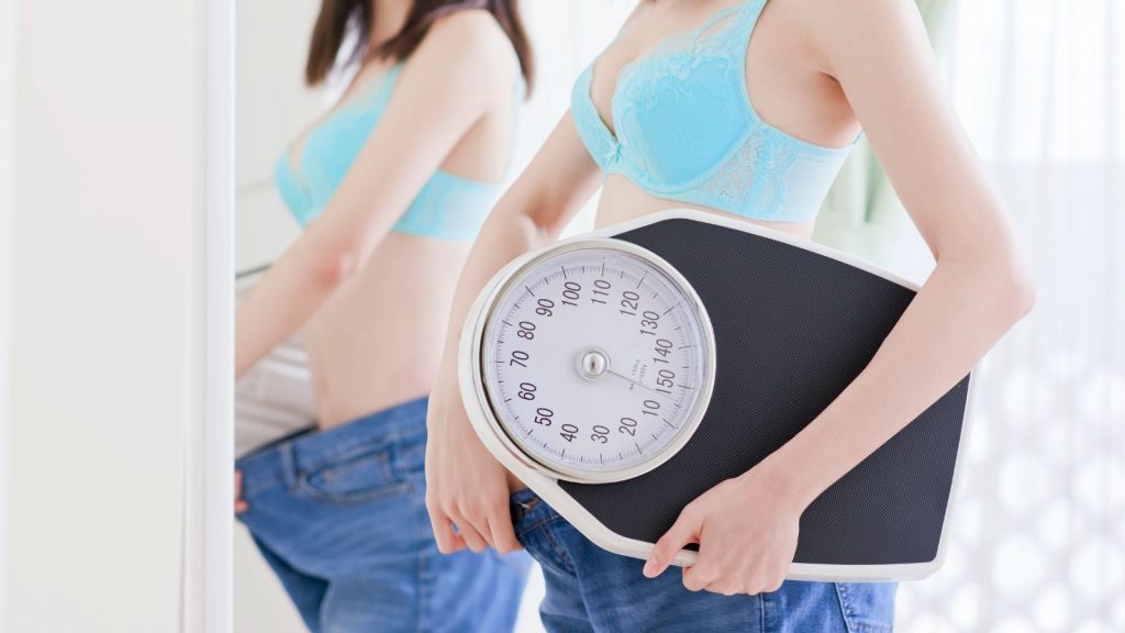 woman checking her weight after weight loss